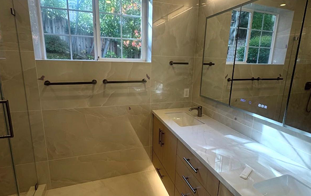 Remodeled bathroom with marble-look tile, floating vanity and glass shower