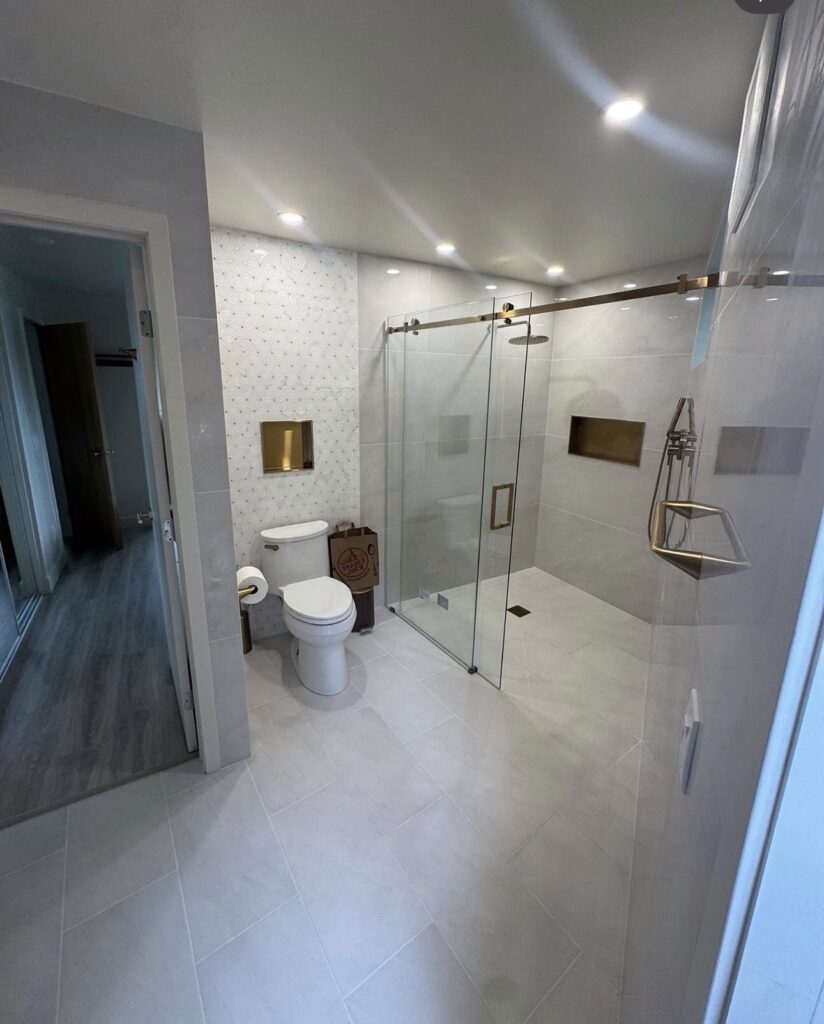 Glass shower enclosure with niche and mosaic floor