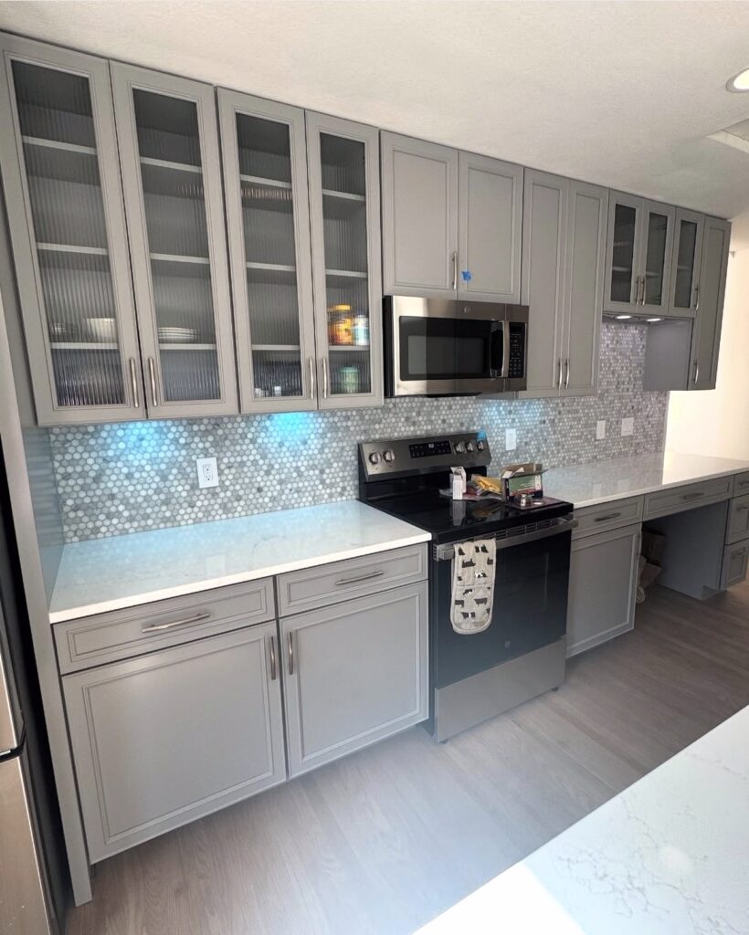Kitchen with glass-front cabinets and mosaic backsplash