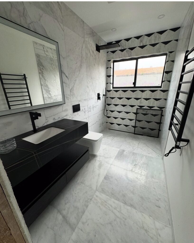 Bathroom with black vanity and geometric accent wall